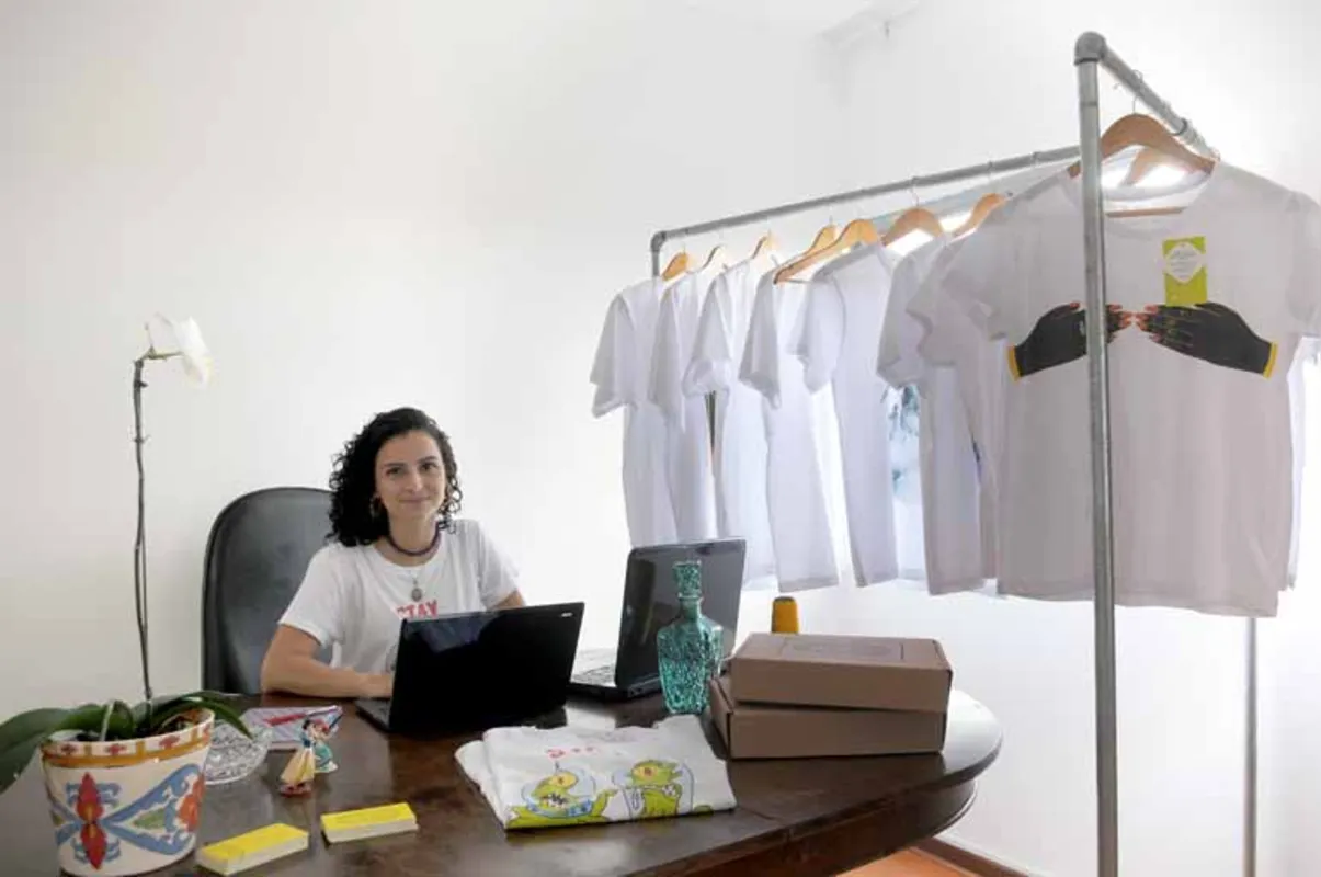Barbara de Moraes comercializa camisas com estampas originais pelo site "Escapiário"; discos, filmes e a cultura brasileira inspiram as criações da designer