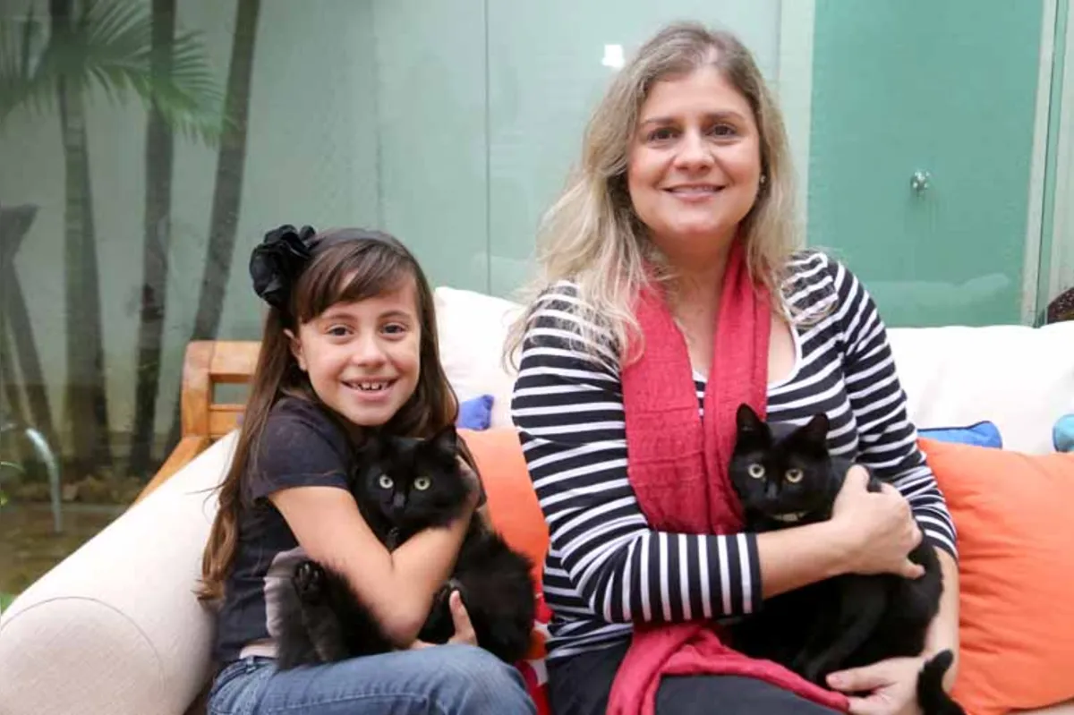 "Não sou supersticiosa, mas se for avaliar, tenho mais sorte que azar", diz a advogada Mônica Cobres Silva, ao lado da filha Júlia, 8. Família é tutora de cinco gatos, sendo dois pretos