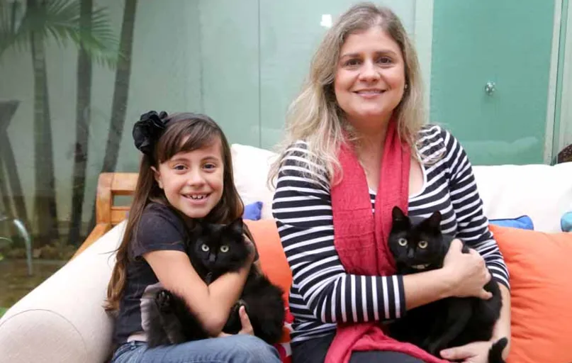 "Não sou supersticiosa, mas se for avaliar, tenho mais sorte que azar", diz a advogada Mônica Cobres Silva, ao lado da filha Júlia, 8. Família é tutora de cinco gatos, sendo dois pretos