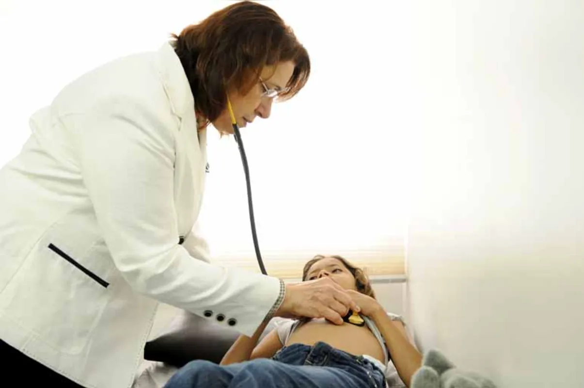 A médica Margarida Carvalho examina Ana Beatriz, diagnosticada com artrite idiopática juvenil
