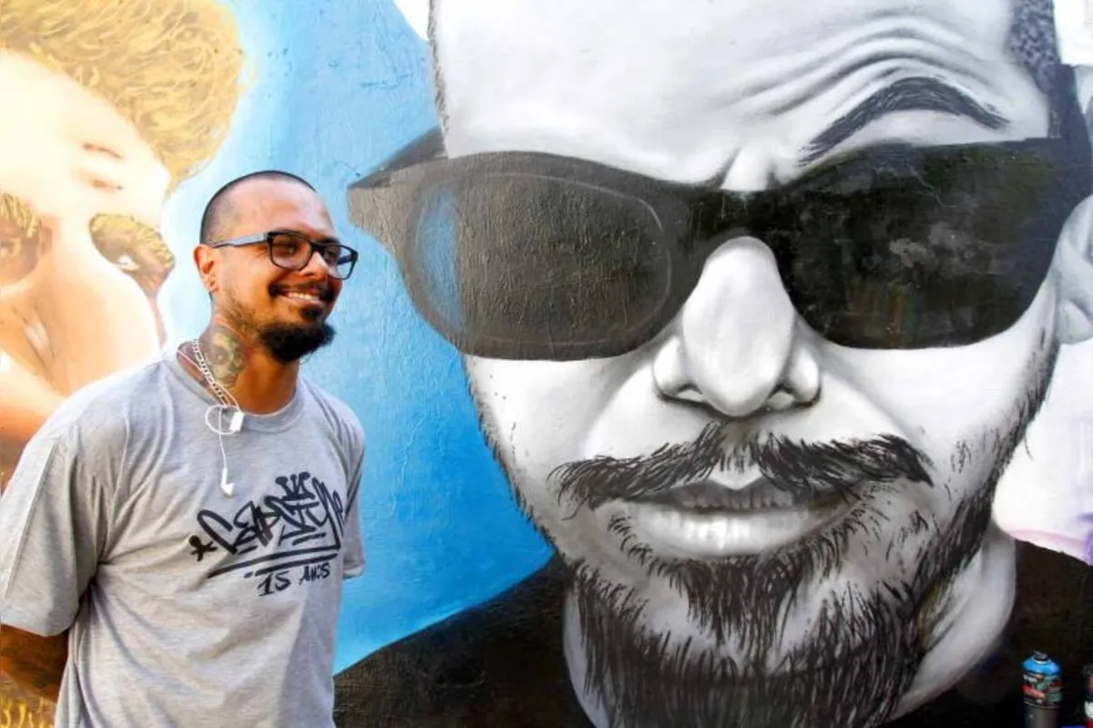 O grafiteiro londrinense Huggo Rocha e seu retrato feito no muro por profissionais de Curitiba que participaram da grafitagem