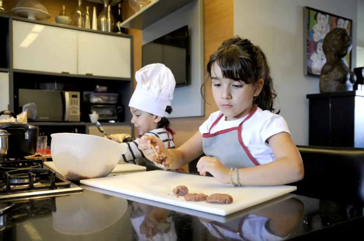 Os irmãos Tomás, 3, e Cecília Mansano, 5, se divertem na cozinha: incentivo da família