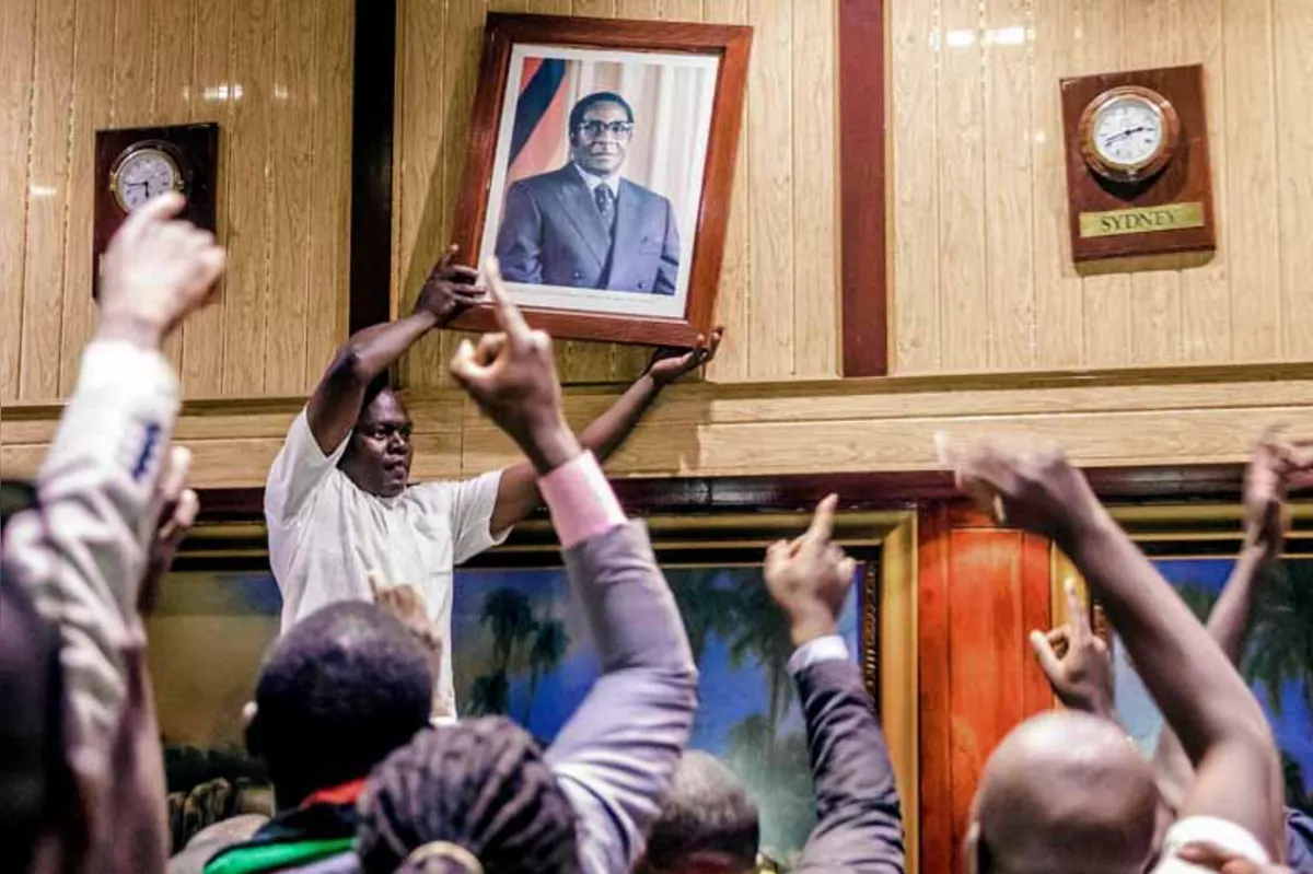 Populares que acompanhavam a sessão do Parlamento retiram o retrato do ex-presidente Robert Mugabe