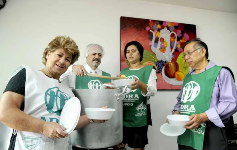 Gessy Aleixo Medri (à frente) e integrantes do grupo da Igreja Adventista que prepara e distribui semanalmente 130 marmitas vegetarianas a pessoas em situação de rua em Londrina