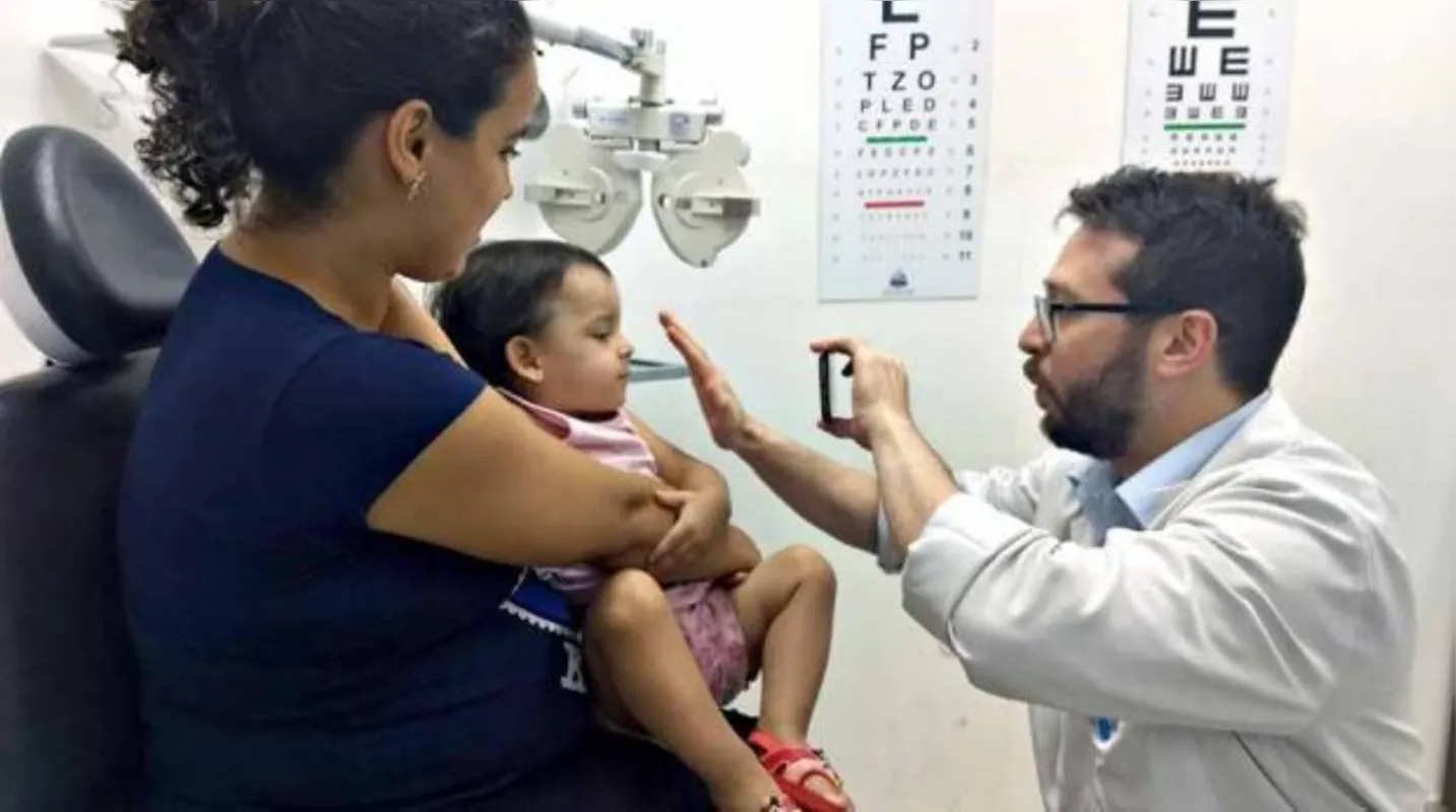 O oftalmologista Eduardo Vidal examina Micaele, de um ano e oito meses de idade; menina foi encaminhada pela pediatra, que notou algo diferente na visão