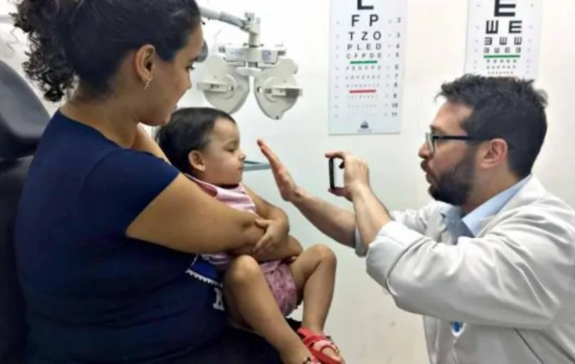 O oftalmologista Eduardo Vidal examina Micaele, de um ano e oito meses de idade; menina foi encaminhada pela pediatra, que notou algo diferente na visão