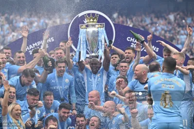 Manchester City's Brazilian midfielder Fernandinho lifts the Premier League trophy as City players celebrate on the pitch after the English Premier League football match between Manchester City and Aston Villa at the Etihad Stadium in Manchester, north west England, on May 22, 2022. - Manchester City won the Premier League for the fourth time in five seasons after a pulsating title race reached a dramatic conclusion as the champions staged an incredible comeback from two goals down to beat Aston Villa 3-2 on Sunday. (Photo by Oli SCARFF / AFP) / RESTRICTED TO EDITORIAL USE. No use with unauthorized audio, video, data, fixture lists, club/league logos or 'live' services. Online in-match use limited to 120 images. An additional 40 images may be used in extra time. No video emulation. Social media in-match use limited to 120 images. An additional 40 images may be used in extra time. No use in betting publications, games or single club/league/player publications. /