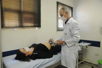 O médico ginecologista Luiz Carlos Baldo, com a paciente Mariana de Oliveira,  observa que o índice de pré-natal é bom no Paraná por causa da oferta do serviço de forma acessível