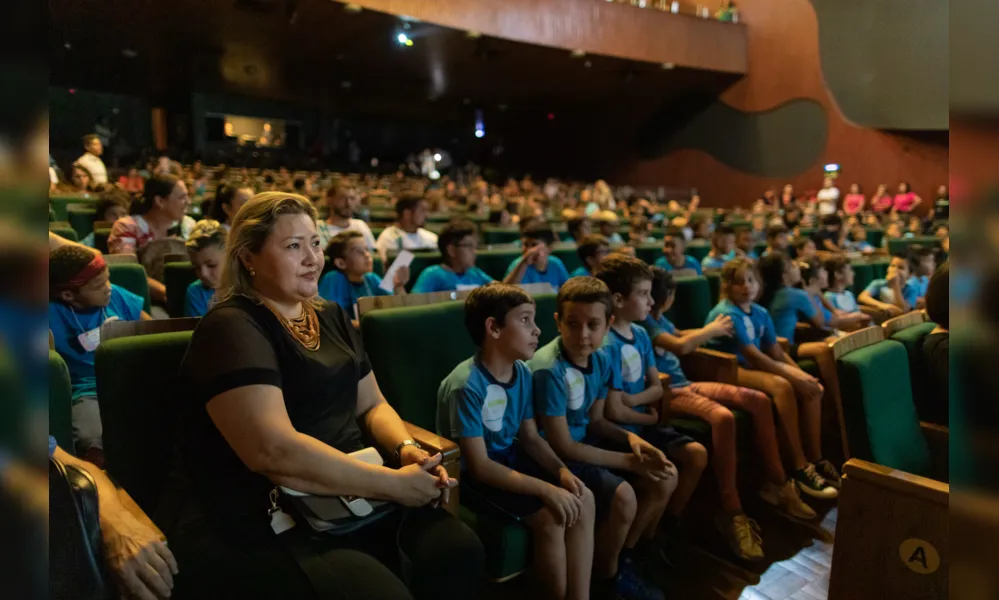 A vice-diretora da Escola Arthur Thomas, Cristiane Tokairin com o público de adultos e crianças presente ao Teatro Ouro Verde para o lançamento do projeto Osquestrando o Futuro