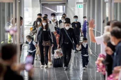 Viajantes da China são recebidos por parentes e funcionários da saúde no aeroporto de Bangkok, na Tailândia