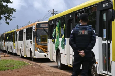 Supporters of Brazil's far-right ex-president Jair Bolsonaro in custody, are taken in buses by police forces to the Federal police headquarters to have their identities and criminal records checked for their possible implication in vandalism acts during the invasions to the Congress, presidential palace and Supreme Court, in Brasilia, on January 9, 2023, a day after the pro-Bolsonaro mob ran riots. - Brazilian security forces locked down the area around Congress, the presidential palace and the Supreme Court Monday, a day after supporters of ex-president Jair Bolsonaro stormed the seat of power in riots that triggered an international outcry. Hardline Bolsonaro supporters have been protesting outside army bases calling for a military intervention to stop Lula from taking power since his election win. (Photo by MAURO PIMENTEL / AFP)