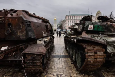Pedestres olham para os veículos militares russos destruídos em uma exposição ao ar livre de equipamentos russos destruídos em Kyiv, em 5 de janeiro de 2023.