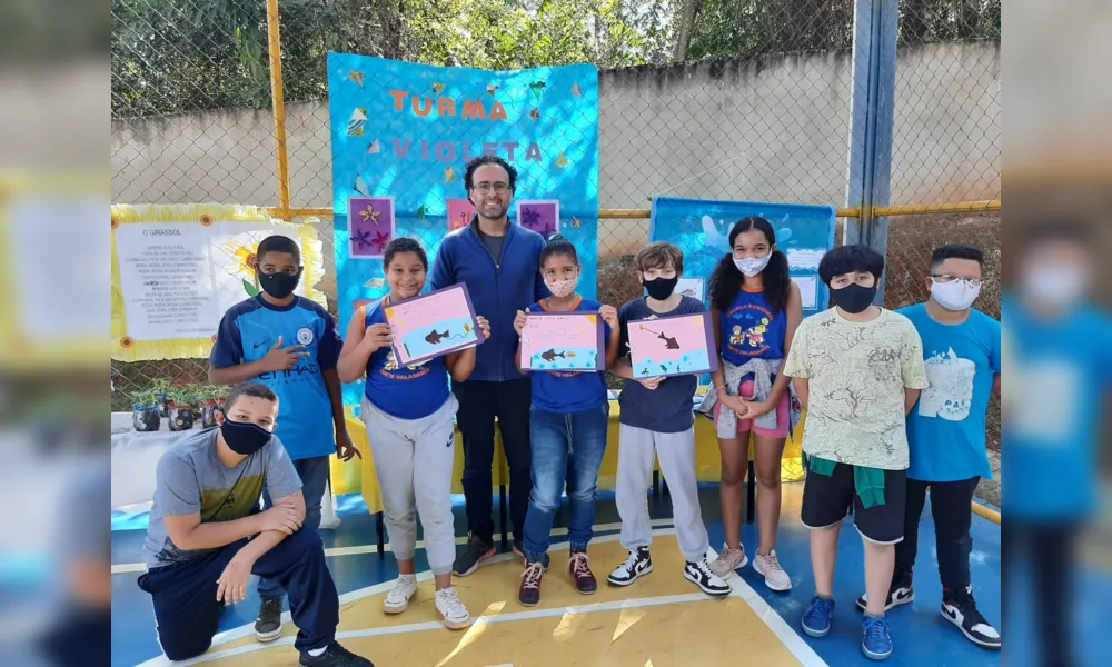 O escritor Thiago cascabulho com alunos contemplados pelo Projeto Douradinho