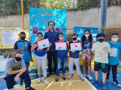 O escritor Thiago cascabulho com alunos contemplados pelo Projeto Douradinho