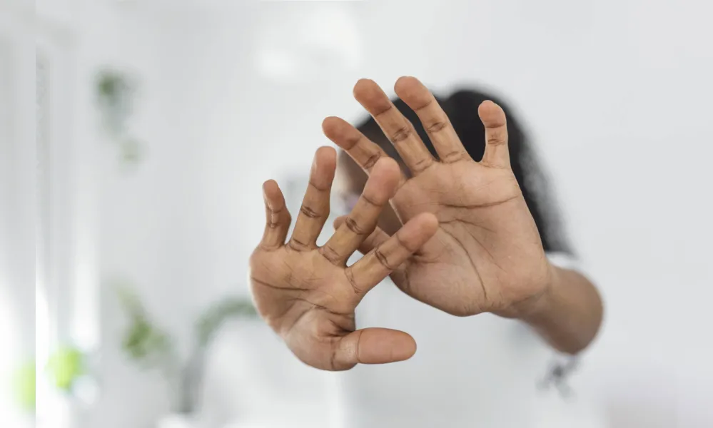 Woman defending herself from attack. Stop. Hands outstretched. campaign stop violence against women. African American woman raised her hand for dissuade with copy space
