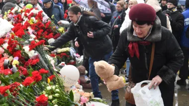 Pessoas depositam flores e brinquedos em um memorial improvisado na Rússia: homenagem