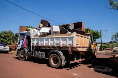 Funcionários da prefeitura recolhem móveis e outros materiais deixados pelos moradores em frente de suas casas