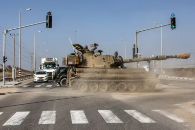 Obus da artilharia israelense atravessa estrada ao longo da Faixa de Gaza onde os combates  se intensificam