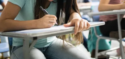 Teenage student writing in the classroom