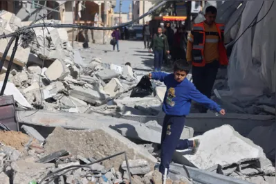 Criança caminha sobre destroços de prédio destruído por míssil israelense em Rafah