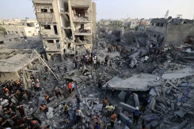 Pessoas verificam os danos causados ​​por um ataque israelense ao Al-Maghazi campo de refugiados em Deir Balah, no centro da Faixa de Gaza, no domingo (5), quando morreram cerca de 45 pessoas
