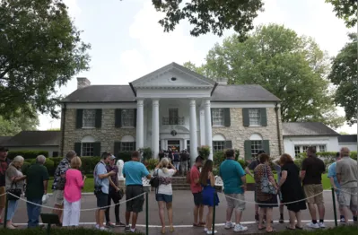 (FILES) Visitors queue to enter Elvis Presley's Graceland mansion on August 12, 2017 in Memphis, Tennessee. A judge in Tennessee on May 22, 2024 temporarily halted a foreclosure sale of Graceland, the historic home of Elvis Presley in the southern US state. The auction of the property had been scheduled to take place on Thursday but was paused by Shelby County Chancellor JoeDae Jenkins. Presley's granddaughter, actress Riley Keough, had filed a lawsuit seeking to block the sale of the sprawling estate in Memphis. (Photo by Mandel Ngan / AFP)
