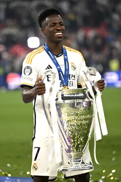 Real Madrid's Brazilian forward #07 Vinicius Junior poses with the trophy to celebrate the victory at the end of the UEFA Champions League final football match between Borussia Dortmund and Real Madrid, at Wembley stadium, in London, on June 1, 2024. (Photo by INA FASSBENDER / AFP)