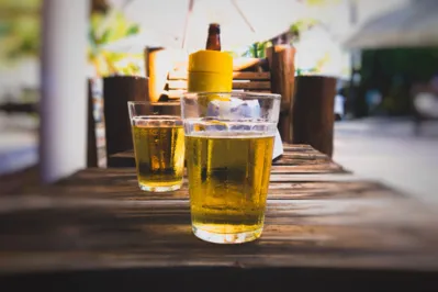 Glass of cold beer on wooden table at bar in summer. Bar on the beach
