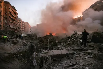 People and rescuers gather near the smouldering rubble of a building destroyed in an Israeli air strike in the Haret Hreik neighbourhood of Beirut's southern suburbs on September 27, 2024. A source close to Hezbollah said the massive Israeli strikes on Beirut's southern suburbs flattened six buildings. (Photo by Ibrahim AMRO / AFP)