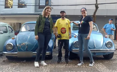 Querolaine, Marcus e Marina, ao lados de alguns exemplares dos famosos Fuscas azuis