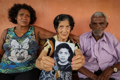 Célia Regina (irmã) e os pais nonagenários Maria Ferreira e Serafim Silva mostram o retrato que guardam de Elisângela Silva