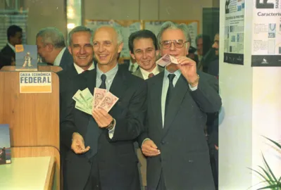 O ministro da Fazenda, Rubens Ricupero, e o presidente Itamar Franco mostram as cédulas de reais após troca das notas de cruzeiros reais