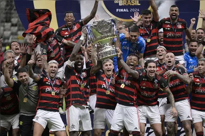 Flamengo players celebrate with the trophy after winning the Brazil Cup final second leg football match between Atletico Mineiro and Flamengo at the MRV Arena Stadium in Belo Horizonte, Brazil, on November 10, 2024. (Photo by DOUGLAS MAGNO / AFP)