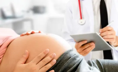 Happy pregnant woman visit gynecologist doctor at hospital or medical clinic for pregnancy consultant. Doctor examine pregnant belly for baby and mother healthcare check up. Gynecology concept.