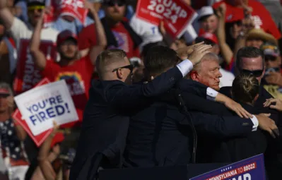 Agentes do Serviço Secreto cercam o ex-presidente republicano Donald Trump no palco depois que ele foi ferido em um comício em Butler, Pensilvânia