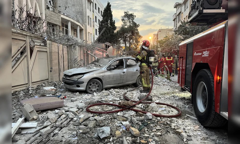Equipes de emergência se reúnem em frente a um prédio atingido por um ataque israelense em Teerã, capital do Irã, no dia 12 de junho