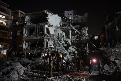 Tropas israelenses e socorristas se reúnem em frente a um prédio atingido por um míssil disparado do Irã, em Ramat Gan, perto de Tel Aviv