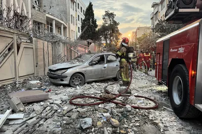 Equipes de emergência se reúnem em frente a um prédio atingido por um ataque israelense em Teerã, capital do Irã, no dia 12 de junho