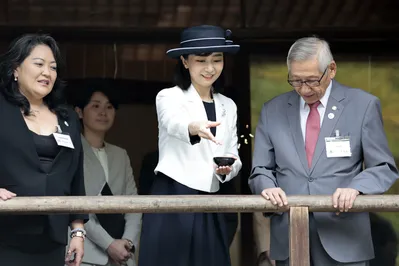 Princesa do Japão, Kako de Akishino, alimenta carpas ao lado Roberto Nishio, presidente da Sociedade Brasileira de Cultura japonesa, durante visita ao monumento em homenagem aos pioneiros da imigração japonesa falecidos