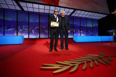 O diretor brasileiro Kleber Mendonça Filho recebe o prêmio de Melhor Diretor pelo filme "O Agente Secreto" das mãos do diretor francês Claude Lelouch durante a cerimônia de encerramento da 78ª edição do Festival de Cinema de Cannes, em Cannes, sul da França, em 24 de maio de 2025