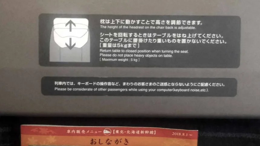 "Por favor, seja atencioso com outros passageiros enquanto usa seu computador (barulho do teclado, etc.)", diz adesivo na parte de trás dos bancos dos trens-bala japoneses