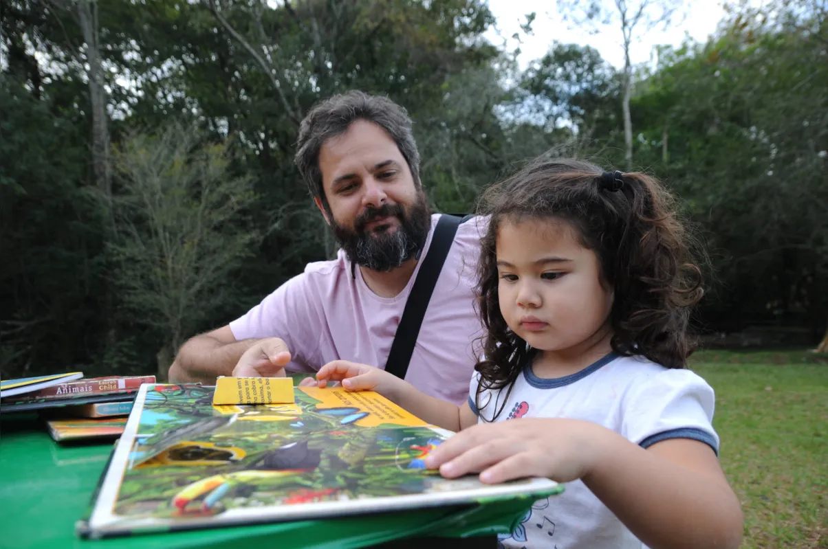  Márcio Novak e a filha Giovana aproveitaram a tarde com os livros da Biblioteca Móvel Ambiental da Sema