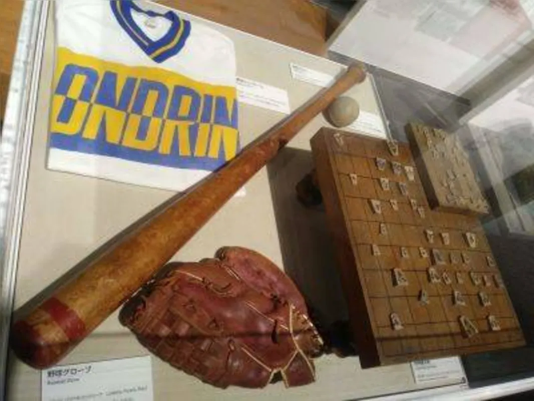 Uniforme e luva de time de beisebol de Londrina no Museu da Migração Japonesa da Jica (Japan International Cooperation Agency) em Yokohama, Japão; com o uniforme, patrocinado pelo empresário Atsushi Yoshii, o time londrinense conquistou diversos títulos na década de 1980; a luva é da fabricante brasileira Fujiya