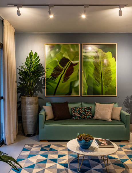 No living, o tom azul da parede faz combinação com o sofá e o geométrico escolhido para o tapete