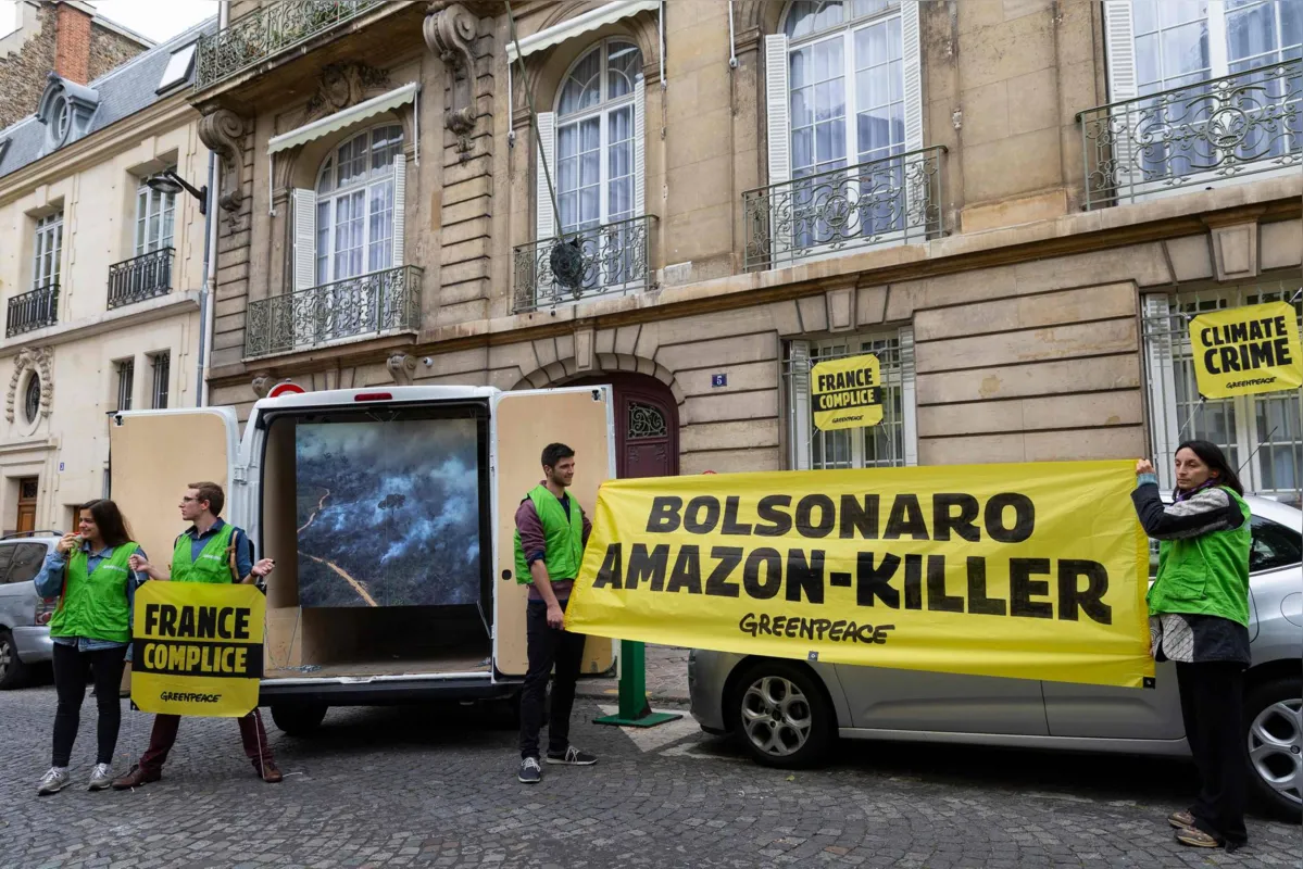 Na rua em frente à residência oficial, ativistas exibiram uma faixa com a mensagem "Bolsonaro assassino da Amazônia" 