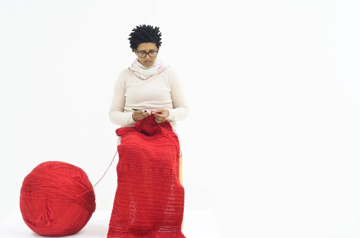 Lerato Shadi (África do Sul): artista esteve na abertura da bienal fazendo uma performance em que tricota, em silêncio, uma peça vermelha