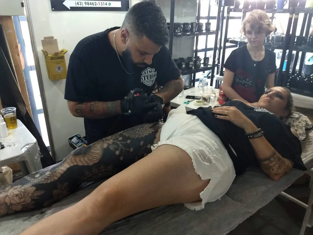 Luiz Alexandre Souza Silva Nino tatua Andreza Afonso Silva durante a Expo Tattoo Londrina