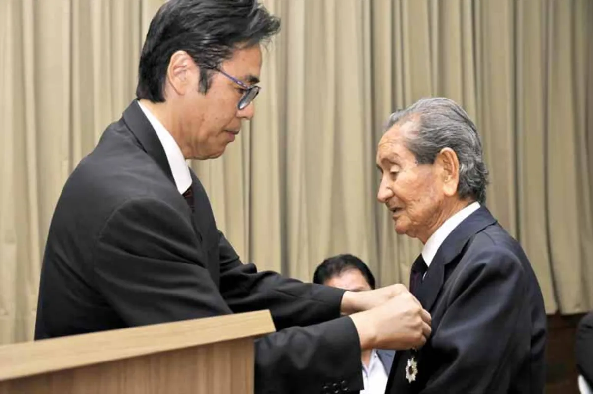 Frank Ogata (à dir.) recebe a condecoração Mérito "Ordem do Sol Nascente, Raios de Ouro e Prata"