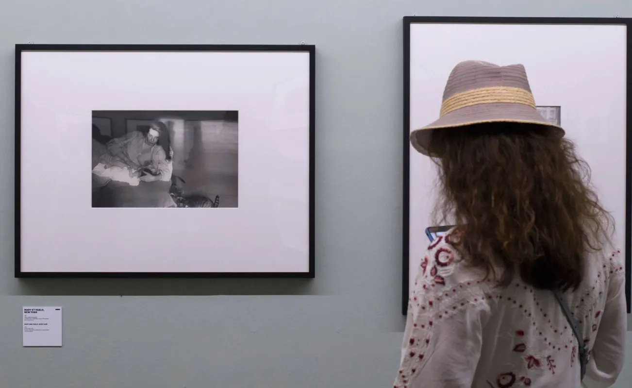 Espectadora observa fortos de Robert Frank em Arles, na França (2018): obra Os Americanos foi baseada nas vivências da Geração Beat 