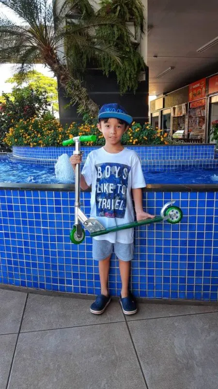 Filipe Hiroshi Santos Numata e o patinete que ganhou no sorteio